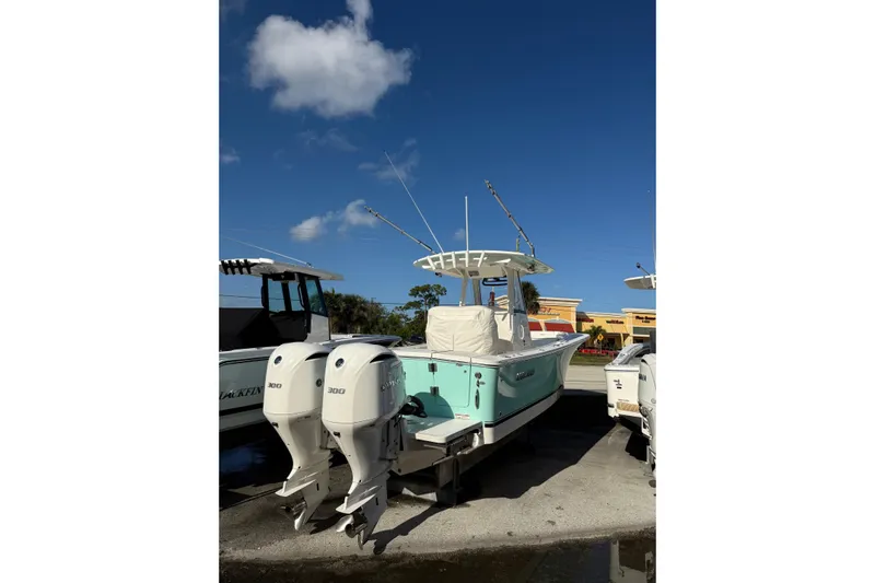 28-563 Brokerage Higgins Yacht Photos Pics 2021 Regulator 28 boat with twin 300 engines, docked under clear blue sky.