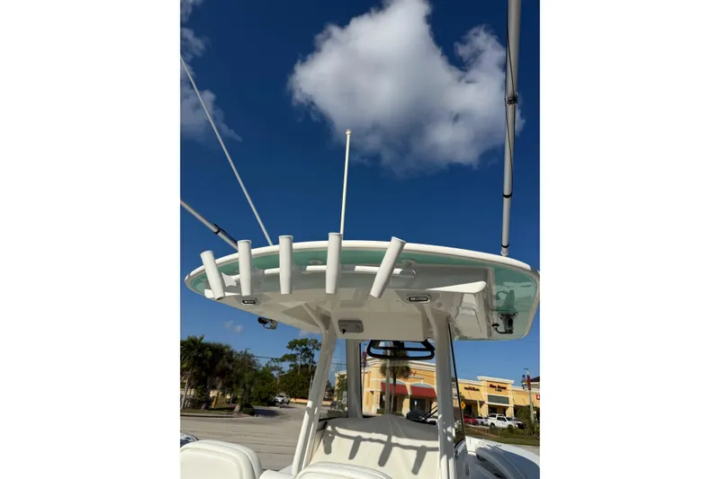28-563 Brokerage Higgins Yacht Photos Pics 2021 Regulator 28 boat with T-top and rod holders under a clear blue sky.