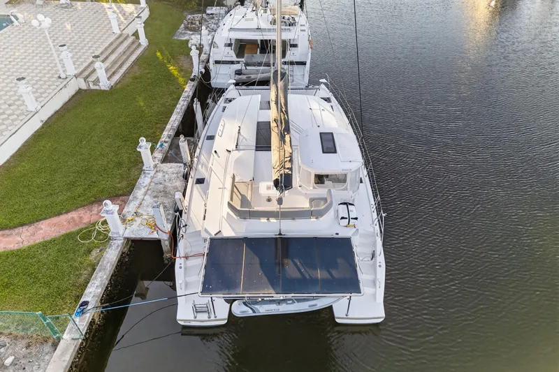 Yacht Photos Pics Aerial view of a 2022 Leopard 45 catamaran docked by a grassy area.