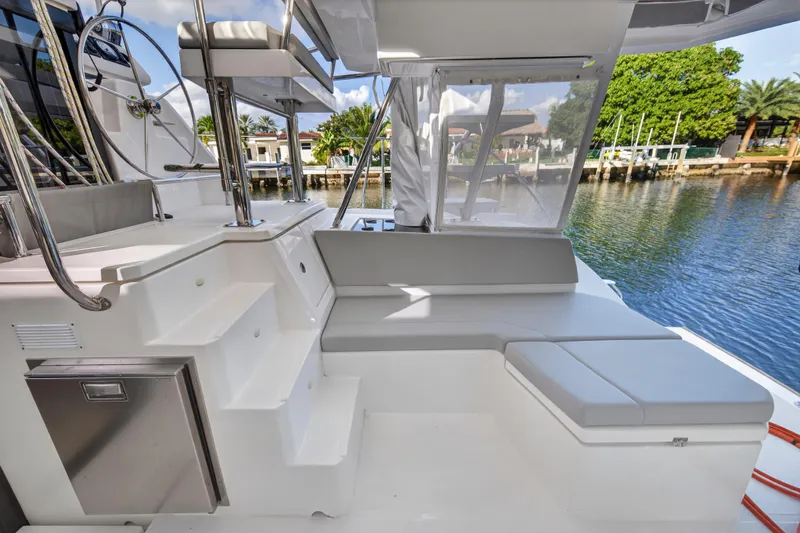  Yacht Photos Pics Luxurious 2022 Leopard 45 yacht interior with seating and helm, docked by serene waterfront.