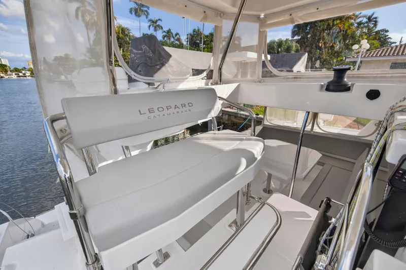  Yacht Photos Pics 2022 Leopard 45 catamaran interior with seating and helm, featuring modern design.