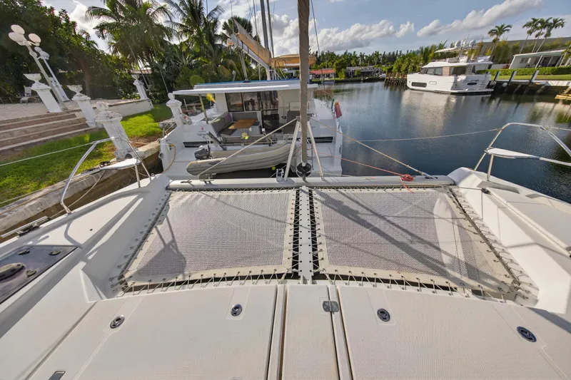  Yacht Photos Pics 2022 Leopard 45 catamaran docked in a serene marina setting.
