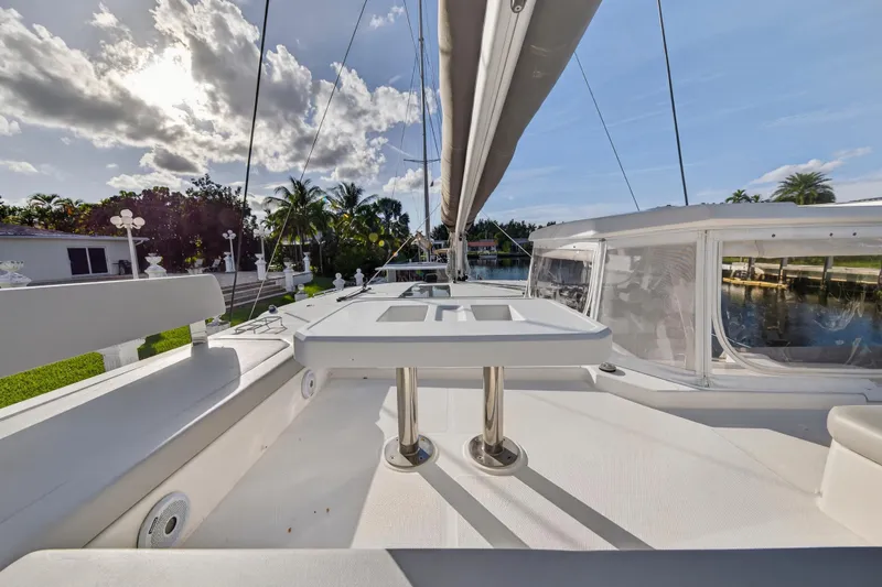 Yacht Photos Pics 2022 Leopard 45 yacht deck with seating, table, and scenic waterfront view.