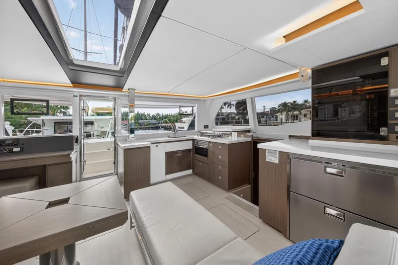  Yacht Photos Pics Luxurious interior of a 2022 Leopard 45 catamaran, featuring modern kitchen and seating area.