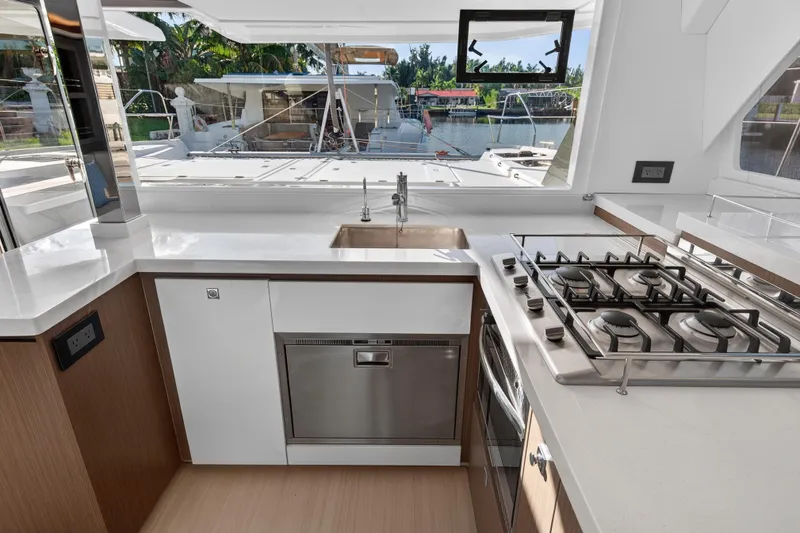  Yacht Photos Pics Modern kitchen interior on 2022 Leopard 45 yacht, featuring stove, sink, and dishwasher.