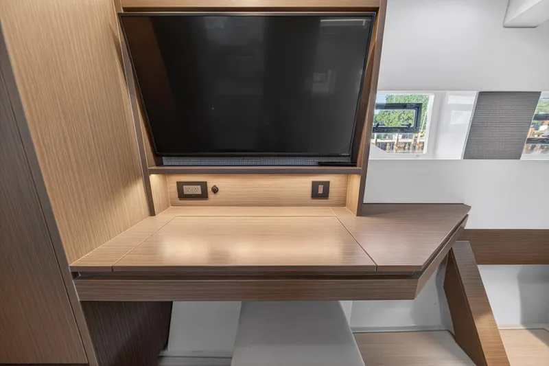  Yacht Photos Pics Modern interior of 2022 Leopard 45 yacht with sleek wooden desk and mounted TV.