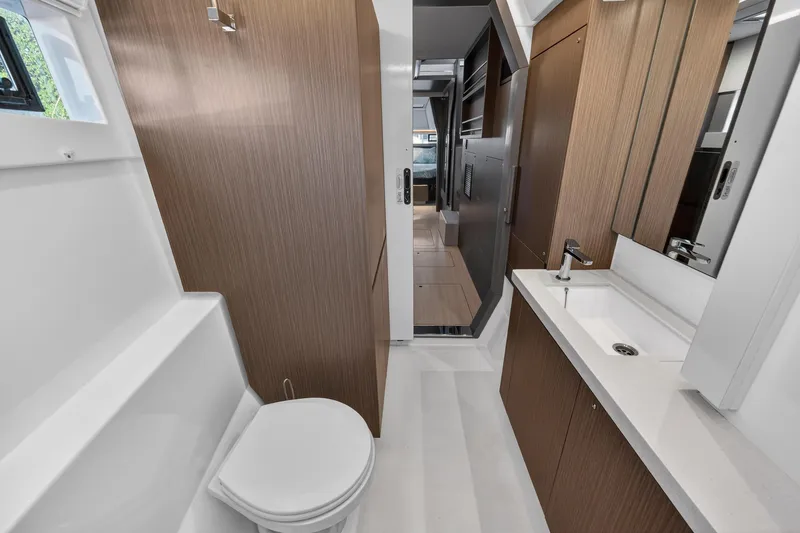  Yacht Photos Pics Modern bathroom interior on 2022 Leopard 45 yacht, featuring sleek wood finishes and white fixtures.