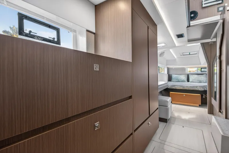  Yacht Photos Pics Modern interior of 2022 Leopard 45 catamaran with sleek wood cabinetry and cozy sleeping area.