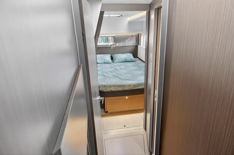  Yacht Photos Pics Modern bedroom interior on 2022 Leopard 45 yacht, featuring cozy bed and sleek design.