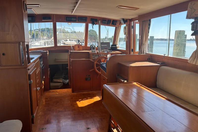 Metagene Yacht Photos Pics Interior of 1988 Grand Banks 42 Classic yacht with wooden furnishings and helm.