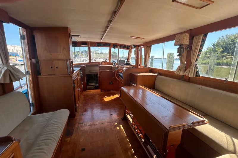 Metagene Yacht Photos Pics Interior of 1988 Grand Banks 42 Classic yacht with wooden furnishings and large windows.