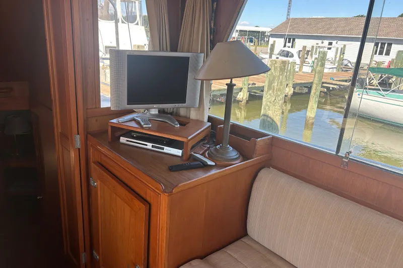 Metagene Yacht Photos Pics Interior of 1988 Grand Banks 42 Classic yacht with TV, lamp, and wooden cabinetry.