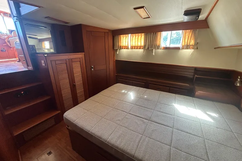 Metagene Yacht Photos Pics Cozy cabin interior of 1988 Grand Banks 42 Classic yacht with bed and wooden furnishings.