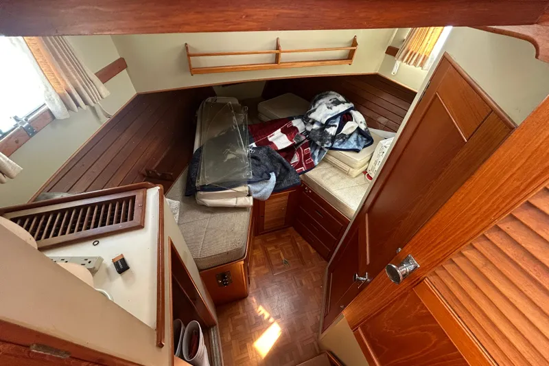 Metagene Yacht Photos Pics Interior cabin of 1988 Grand Banks 42 Classic yacht with wooden furnishings and bedding.