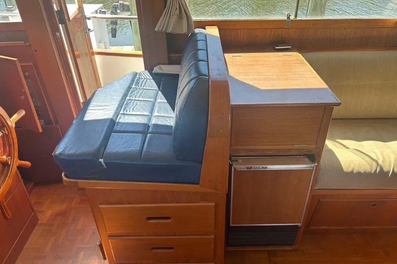 Metagene Yacht Photos Pics Interior of 1988 Grand Banks 42 Classic yacht with blue cushioned seating and wooden cabinetry.