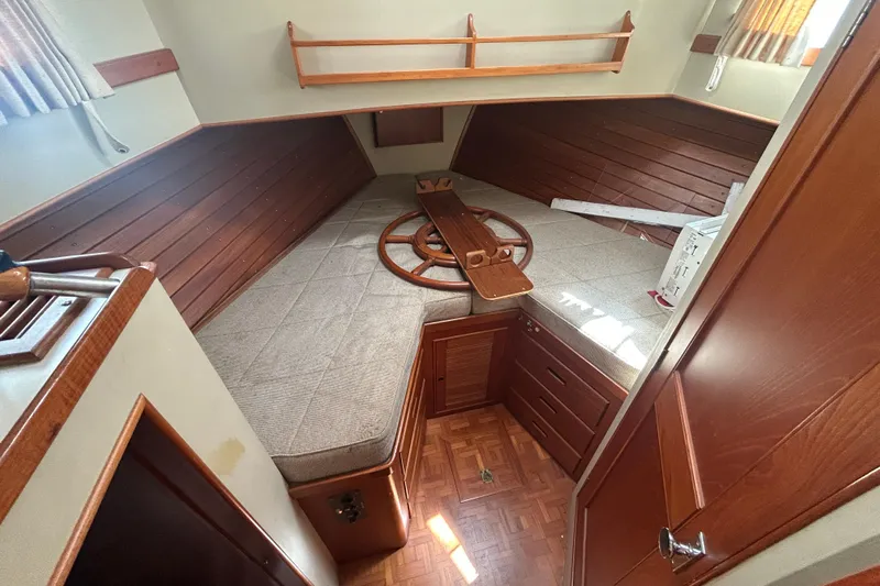 Metagene Yacht Photos Pics Interior cabin of 1988 Grand Banks 42 Classic yacht with wooden accents and cozy bedding.