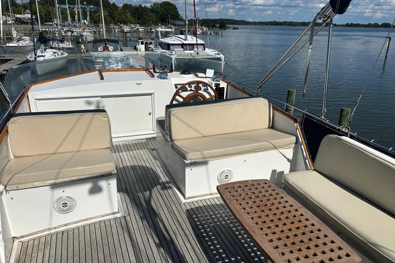 Metagene Yacht Photos Pics 1988 Grand Banks 42 Classic yacht deck with seating and steering wheel, docked by calm waters.