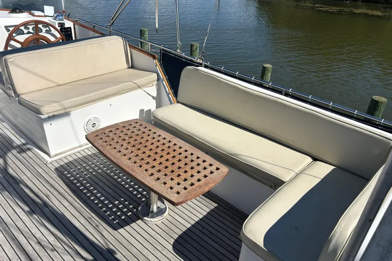 Metagene Yacht Photos Pics 1988 Grand Banks 42 Classic yacht deck with cushioned seating and wooden table.