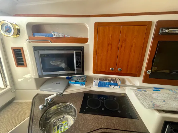  Yacht Photos Pics 2009 Grady-White 330 Explorer boat interior with microwave, sink, and wooden cabinets.