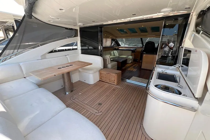  Yacht Photos Pics Luxurious 2010 Princess V62 yacht interior with seating, table, and kitchenette.