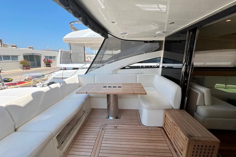  Yacht Photos Pics Luxurious 2010 Princess V62 yacht deck with white seating and wooden table.