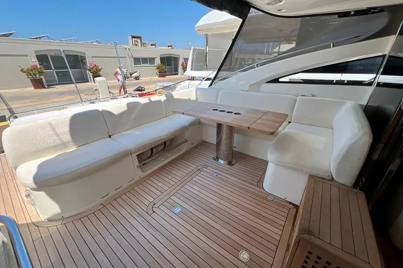  Yacht Photos Pics Luxurious 2010 Princess V62 yacht deck with elegant seating and wooden table.