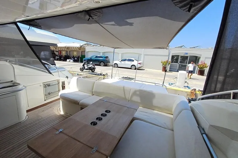  Yacht Photos Pics Luxurious 2010 Princess V62 yacht interior with shaded seating and wooden table.