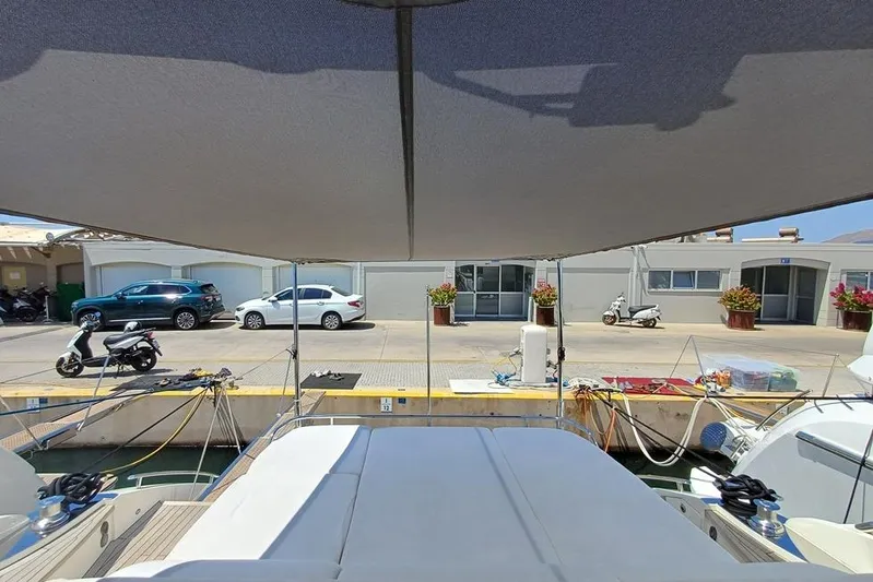  Yacht Photos Pics 2010 Princess V62 yacht docked at marina, shaded deck, nearby parked vehicles.