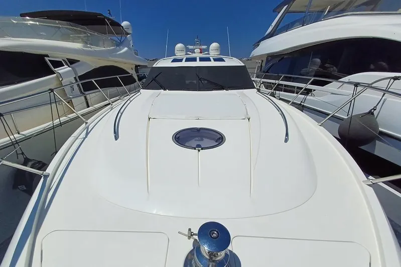  Yacht Photos Pics Luxury yacht Princess V62, 2010 model, docked between other boats under clear blue sky.