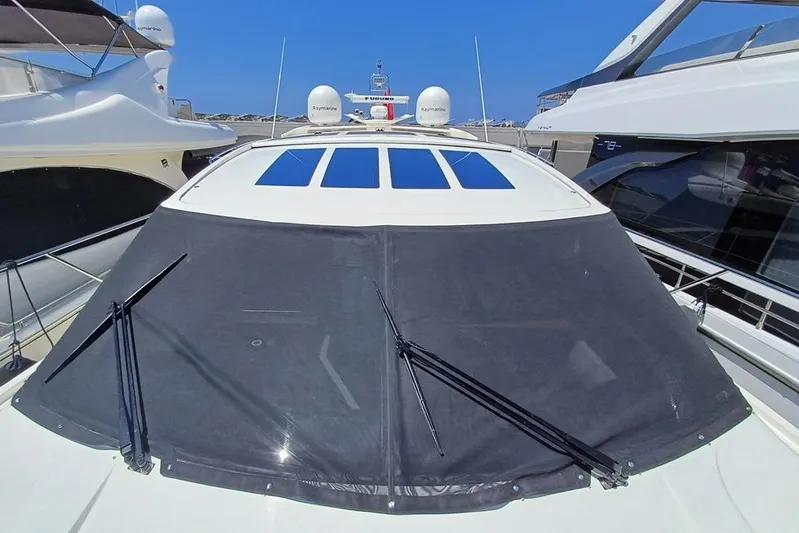  Yacht Photos Pics 2010 Princess V62 yacht with covered windshield, docked between other boats.