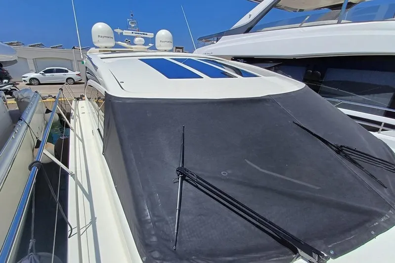  Yacht Photos Pics 2010 Princess V62 yacht with covered deck, docked beside other boats.