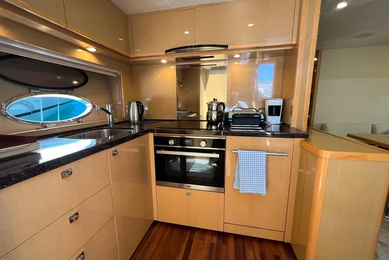  Yacht Photos Pics Luxurious 2010 Princess V62 yacht kitchen with modern appliances and wooden cabinetry.