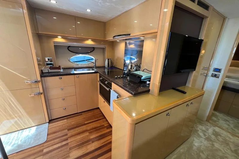  Yacht Photos Pics Luxurious kitchen interior of 2010 Princess V62 yacht with modern amenities and wood flooring.