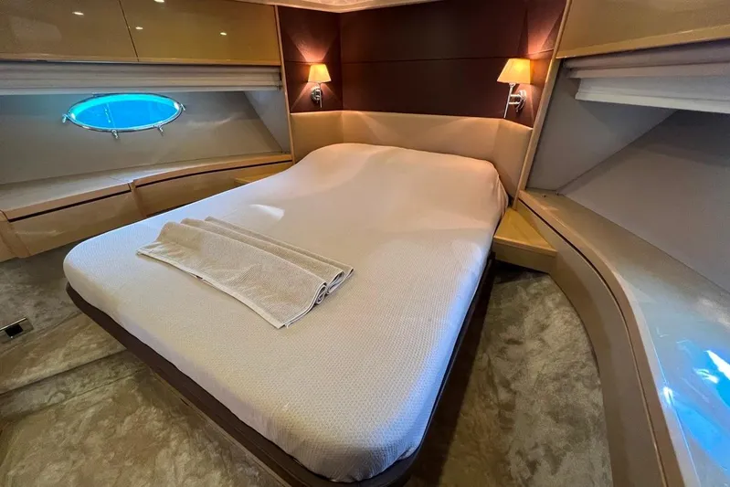  Yacht Photos Pics Luxurious bedroom interior of 2010 Princess V62 yacht with elegant lighting and porthole view.