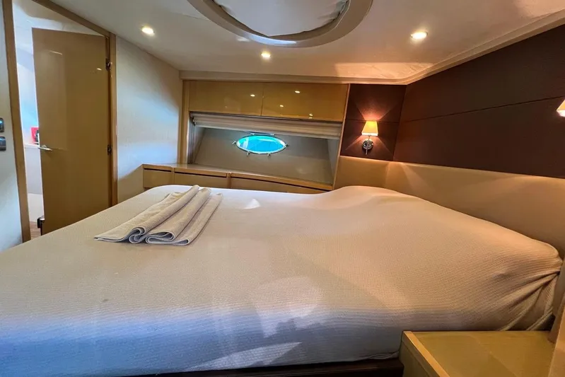  Yacht Photos Pics Luxurious bedroom interior of 2010 Princess V62 yacht with elegant lighting and porthole view.