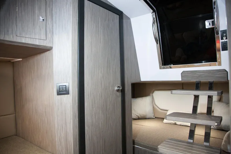  Yacht Photos Pics Interior of 2025 Ranieri NEXT 285 XL boat, featuring modern wood paneling and cozy seating.