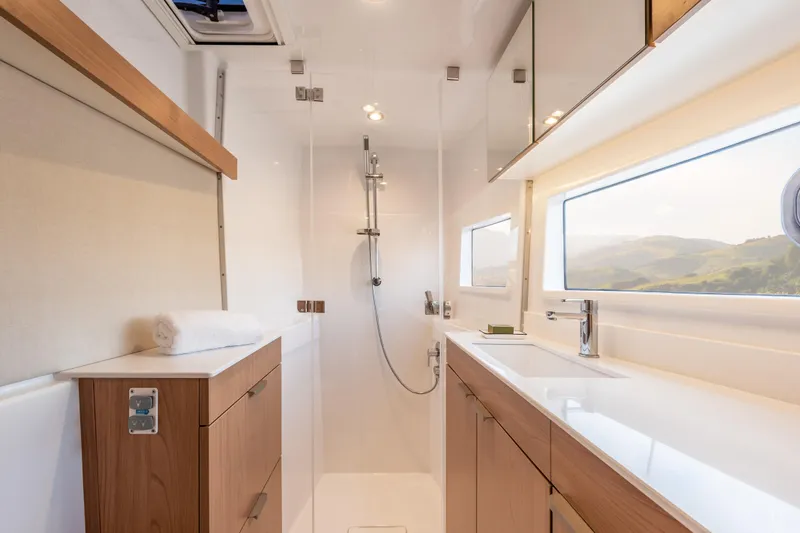 Tbd Yacht Photos Pics Modern yacht bathroom interior with wooden cabinets, sleek fixtures, and large window, Bali CATSMART 2026.