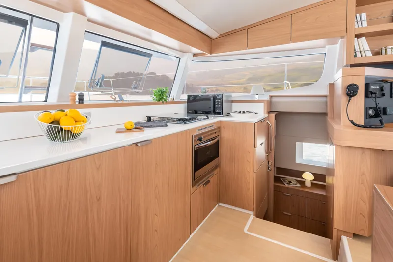 Tbd Yacht Photos Pics Modern yacht kitchen interior with wood finish, featuring appliances and a bowl of lemons. Bali CATSMART 2026.