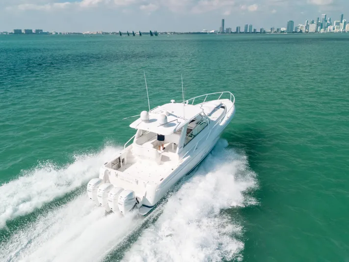  Yacht Photos Pics 2009 Intrepid 475 Sport Yacht cruising on turquoise waters near a city skyline.