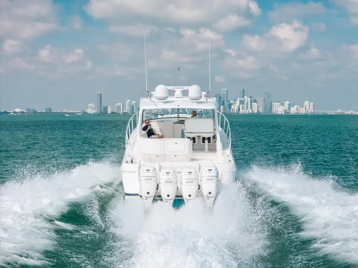  Yacht Photos Pics 2009 Intrepid 475 Sport Yacht cruising on open water with city skyline in background.