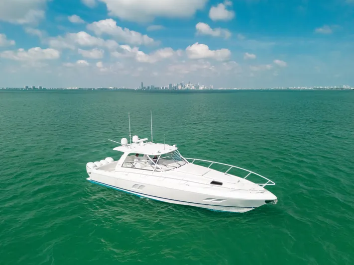  Yacht Photos Pics 2009 Intrepid 475 Sport Yacht on open water with city skyline in background.
