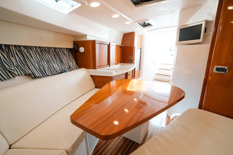  Yacht Photos Pics Luxurious interior of 2009 Intrepid 475 Sport Yacht with wood table and seating.