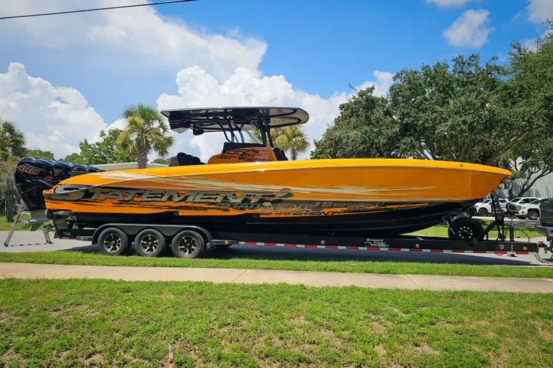  Yacht Photos Pics 2016 Statement 380 Open boat on trailer, vibrant orange design, parked outdoors under blue sky.