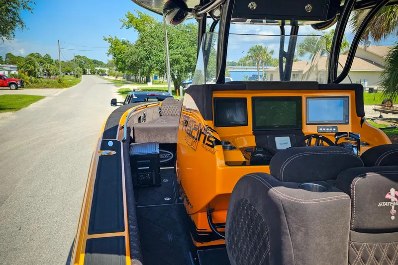  Yacht Photos Pics 2016 Statement 380 Open boat with orange dashboard and modern controls on a sunny street.