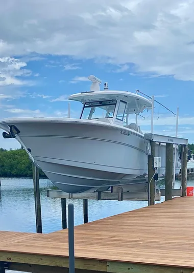  Yacht Photos Pics 2021 Sea Fox 368 Commander boat docked on a lift by a wooden pier.