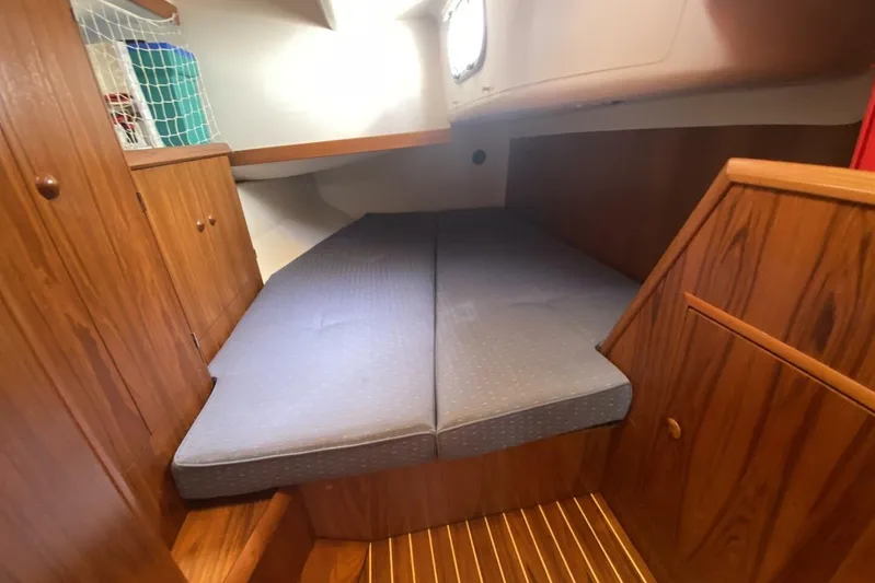 Free Spirits Yacht Photos Pics Cozy cabin interior of 2000 Jeanneau Sun Odyssey 45.2 with wooden finish and cushioned bed.