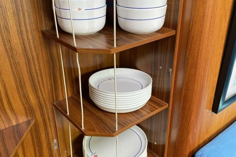 Free Spirits Yacht Photos Pics Wooden shelves with white dishes on Jeanneau Sun Odyssey 45.2, 2000 model.
