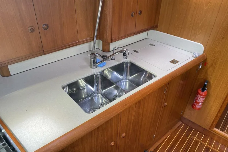 Free Spirits Yacht Photos Pics Galley kitchen in 2000 Jeanneau Sun Odyssey 45.2 yacht with double sink and wooden cabinetry.
