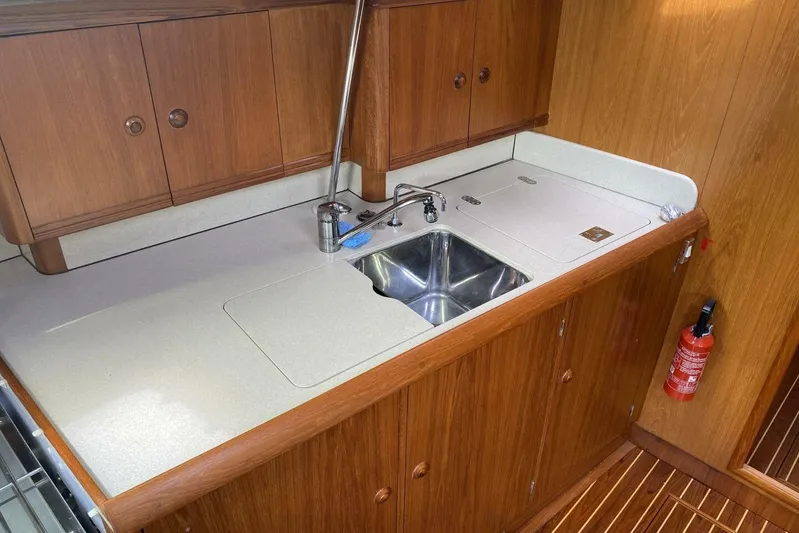 Free Spirits Yacht Photos Pics Jeanneau Sun Odyssey 45.2 yacht kitchen with wooden cabinets and stainless steel sink, 2000 model.