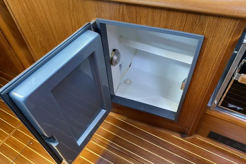 Free Spirits Yacht Photos Pics Open fridge in Jeanneau Sun Odyssey 45.2 yacht, showcasing wooden interior, 2000 model.